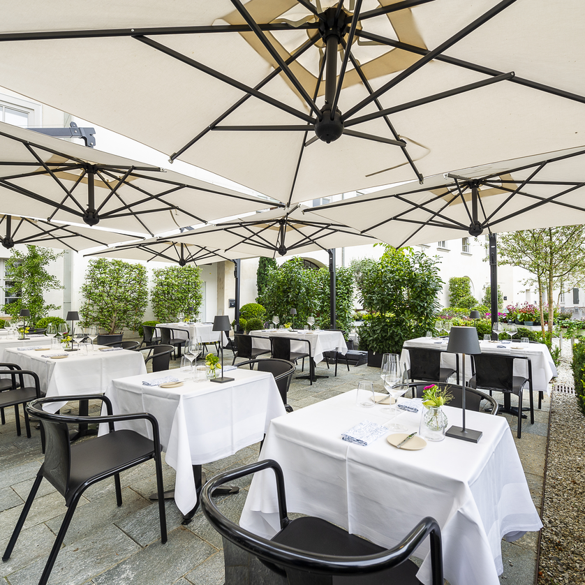 Stammtisch am Paulustor I Essen & Trinken in Graz | © Paul Stajan Gemütliche Terrasse mit weißen Tischen und Sonnenschirmen in Graz. | © Paul Stajan