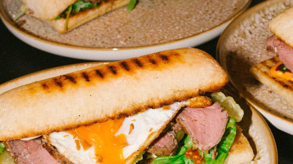 Un panino grigliato con manzo, uovo al tegamino e verdure fresche. | © Bobby's Agency - Simon Bauer