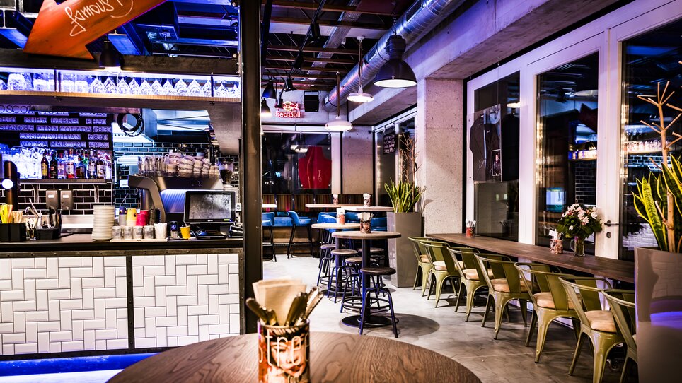Interni di ristorante moderni con bar e aree sedute.