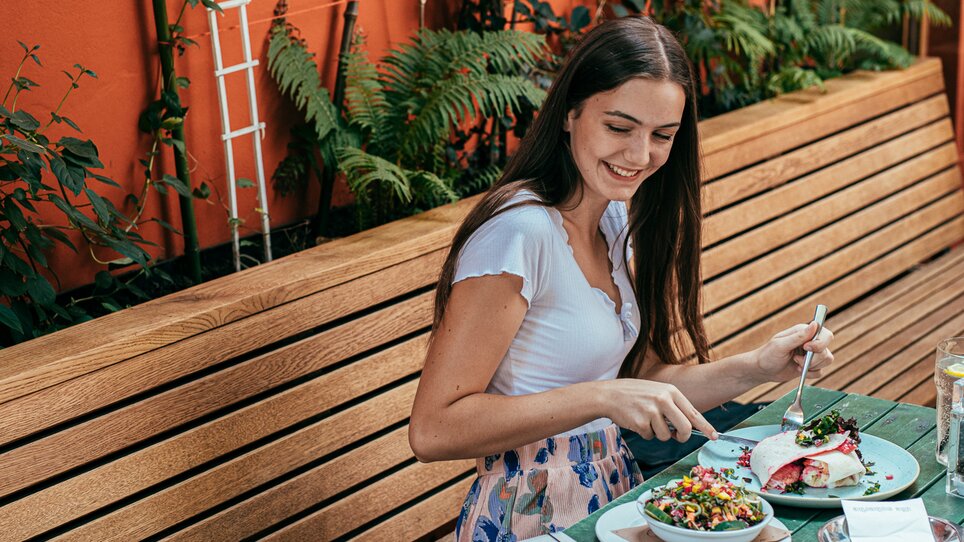 Young woman enjoying a meal at an outdoor setting in Graz. | © Graz Tourismus