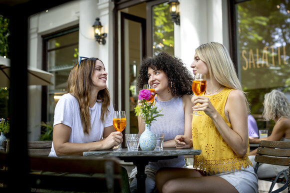 Drei Frauen genießen Drinks bei einem Tisch im Freien. | © Graz Tourismus - Tom Lamm