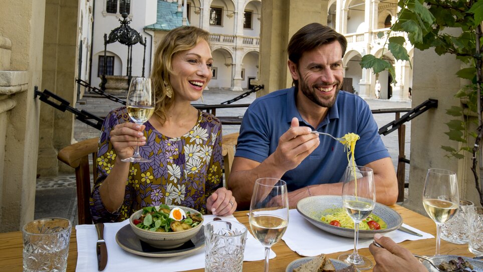 Two people enjoying a meal in the sunlight in Graz. | © Graz Tourismus - Tom Lamm