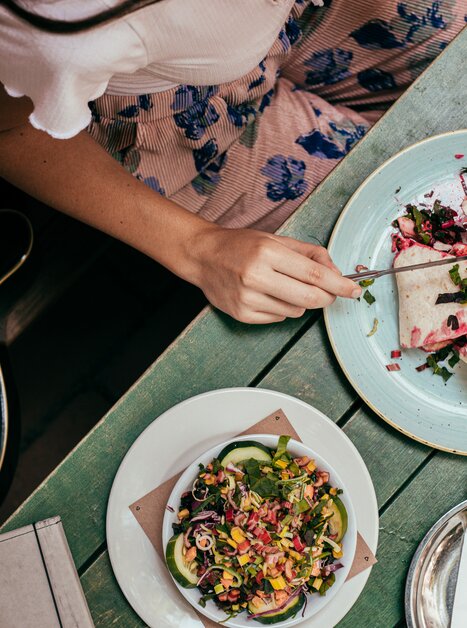 A person enjoys a delicious dish in Graz, with a guitar beside them. | © Graz Tourismus