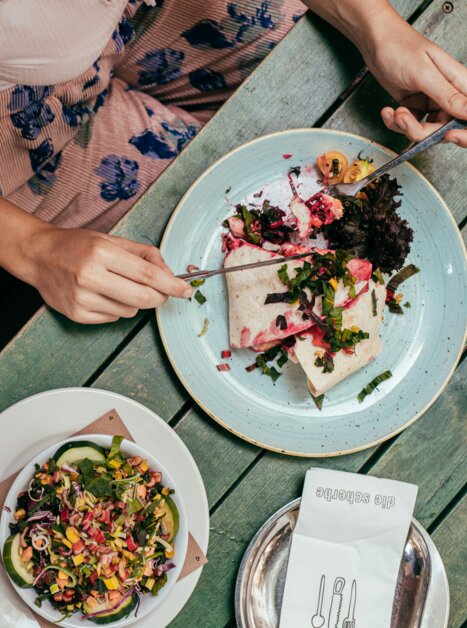 A person enjoys a delicious dish in Graz, with a guitar beside them. | © Graz Tourismus