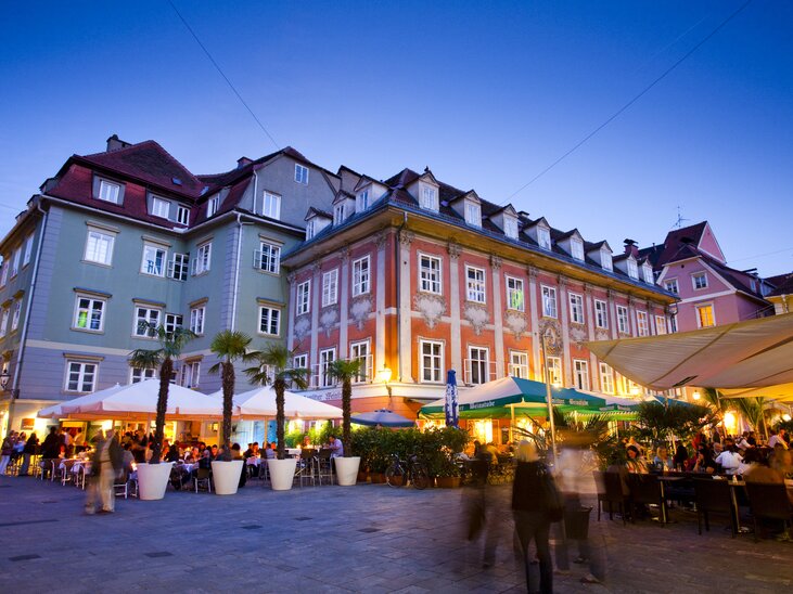 Blick auf einen belebten Platz in Graz mit Restaurants und bunten Gebäuden bei Dämmerlicht. | © Werner Krug