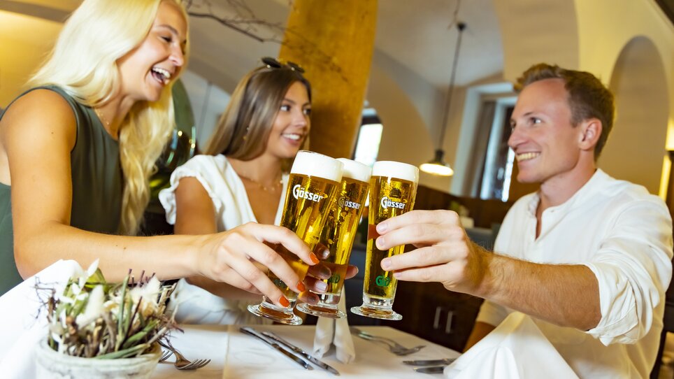 Freunde stoßen mit Biergläsern an und genießen die Zeit in Graz. | © Graz Tourismus - Werner Krug