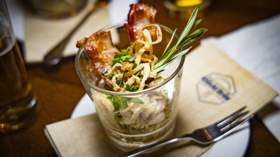 Ein Glas mit herzhaften Zutaten und Speck für den Genuss. | © Graz Tourismus - Werner Krug