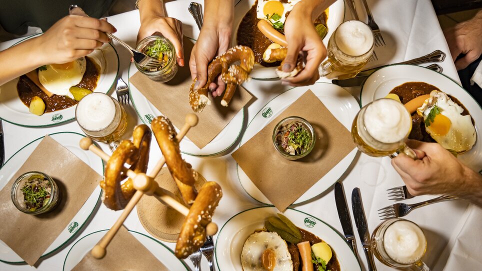 Leckere Speisen und Getränke auf einem Tisch mit Bier und Brezeln. | © Graz Tourismus - Werner Krug