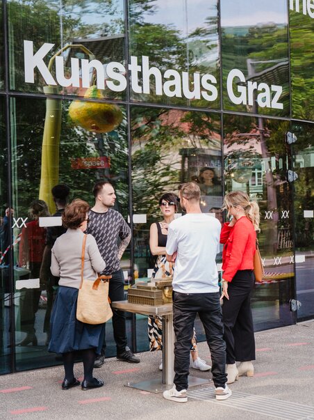 A group of people stands in front of the Kunsthaus Graz on a guided tour of the city. | © 5komma5sinne - MotionAds