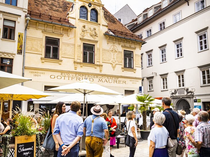 Group of visitors in front of the Glockenspiel at the Glockenspielplatz in Graz. | © Graz Tourismus - Werner Krug