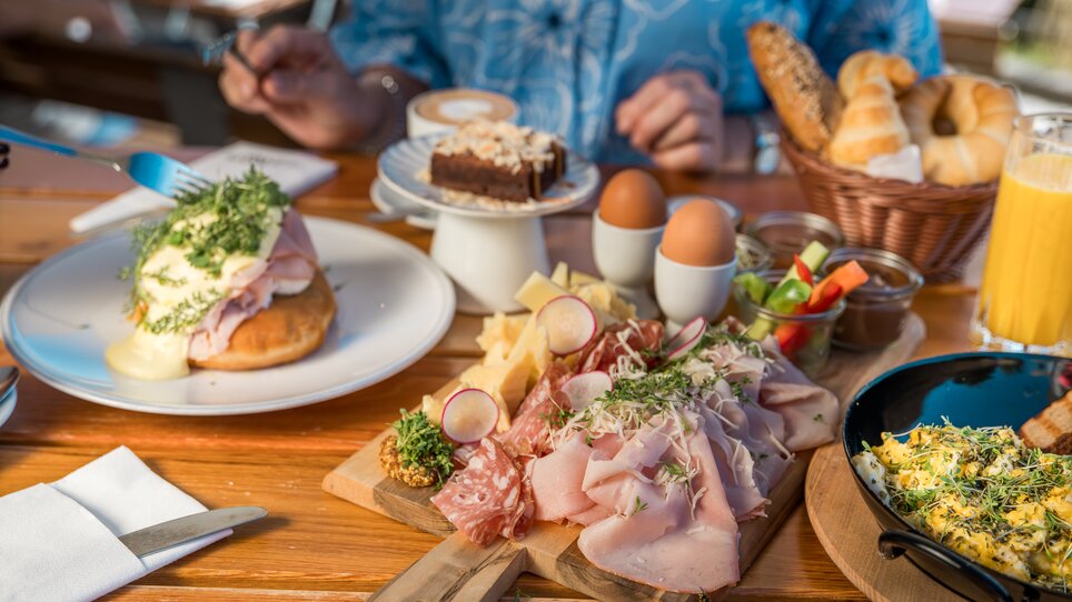 Varied breakfast featuring cheese, meats, eggs, and cake. | © Graz Tourismus_Mias Photoart