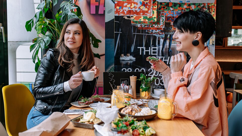 Two women at Kunsthauscafé in Graz enjoying food and drinks. | © 5komma5sinne - Rene Strasser Fotografie 