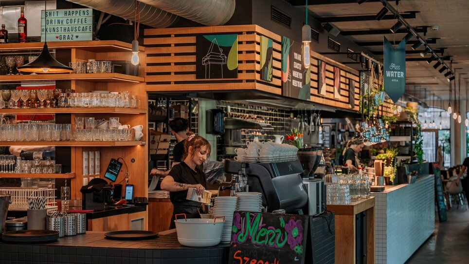 Vista del Kunsthauscafé a Graz con personale e un menu. | © 5komma5sinne - Rene Strasser Fotografie 