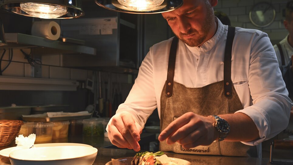 A chef garnishes a plate at the Mohrenwirt restaurant in Graz. | © 5komma5sinne - Rene Strasser Fotografie 