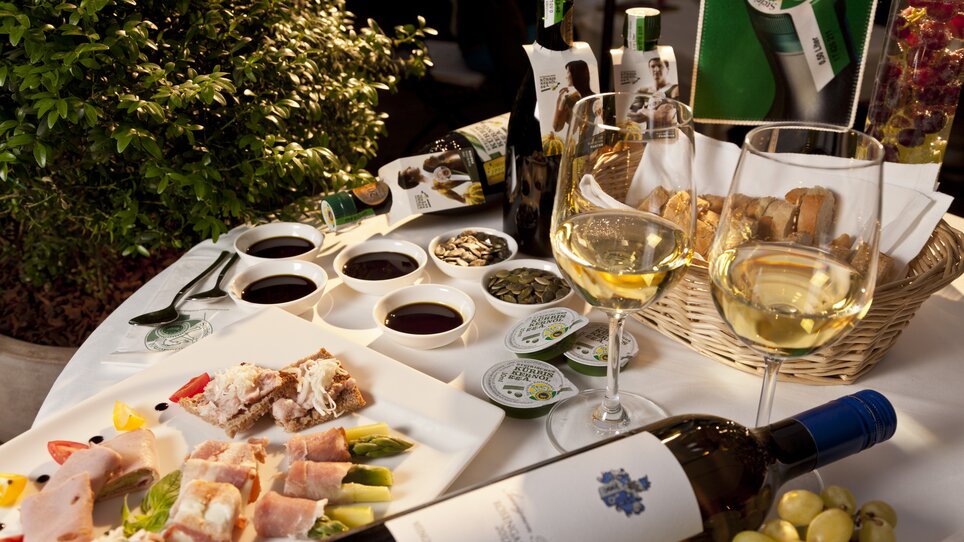 Ein Tisch mit verschiedenen Speisen, Weinen und Kürbiskernöl. | © Graz Tourismus - Werner Krug