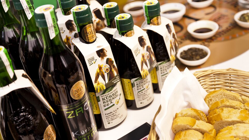 Flaschen mit Kürbiskernöl und frisches Brot bei einer Kernöl-Verkostung. | © Graz Tourismus - Werner Krug