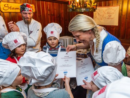 Kinder im Kochkurs erhalten Urkunden nach einem gemeinsamen Koch-Erlebnis. | © Graz Tourismus - Paul Stajan