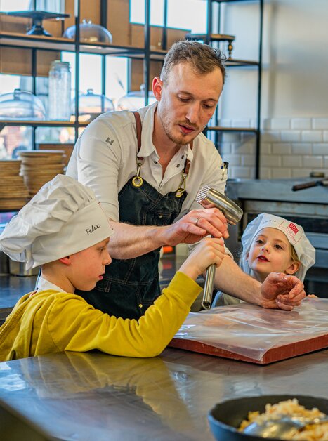 A cooking teacher shows children how to prepare dough. | © Milena Bonstingl