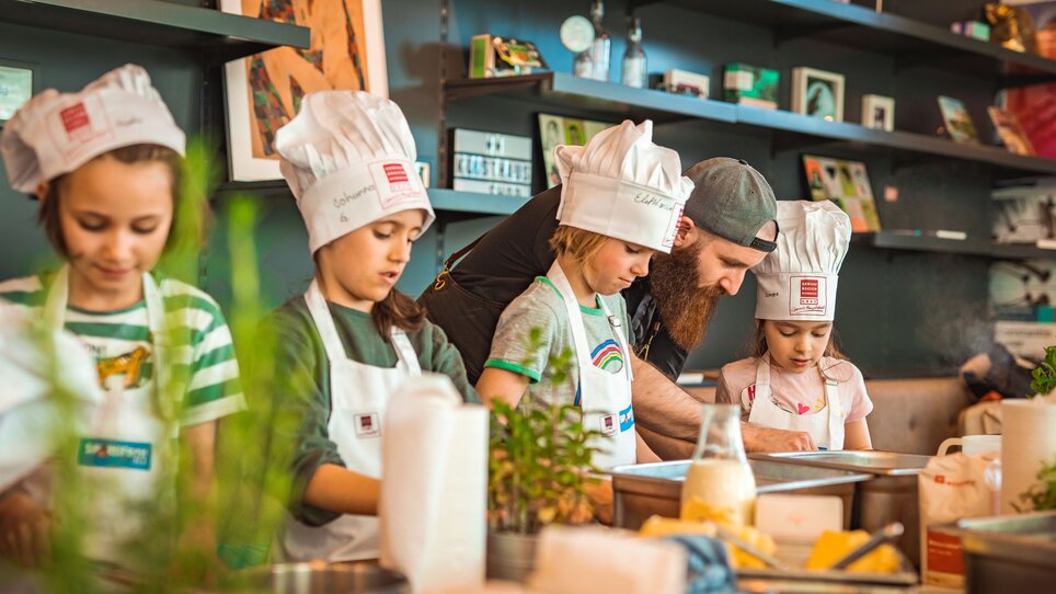 Kinder lernen beim Kochkurs unter Anleitung zu kochen. | © KHC - Bernhard Schindler