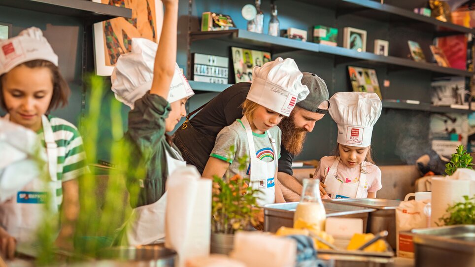Kinder kochen gemeinsam mit einem Koch bei einem Kochkurs in Graz. | © KHC - Bernhard Schindler