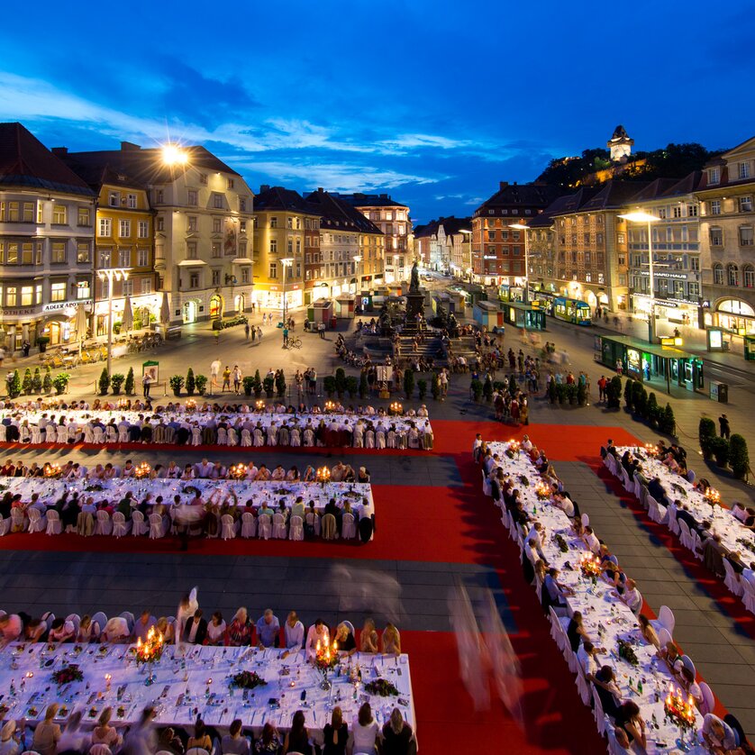 Festliche lange Tafel in Graz bei Dämmerung mit Gästen. | © Graz Tourismus - Harry Schiffer