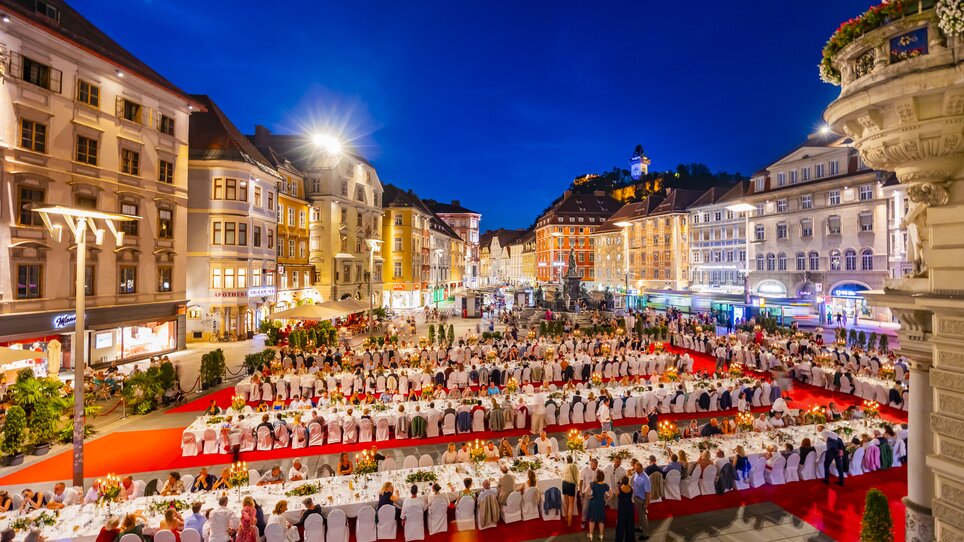 Festliche Tafel im Freien mit Gästen in Graz bei Nacht. | © Graz Tourismus - Werner Krug