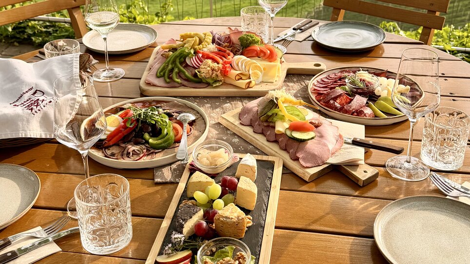 Tantalizing platters of cheese, meats, and fresh vegetables on a table. | © Schanzlwirt