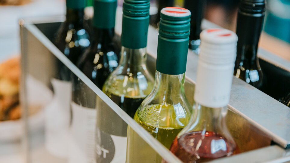 A selection of wine bottles in a rack, including red and white wines. | © Wein Steiermark - Johanna Lamprecht
