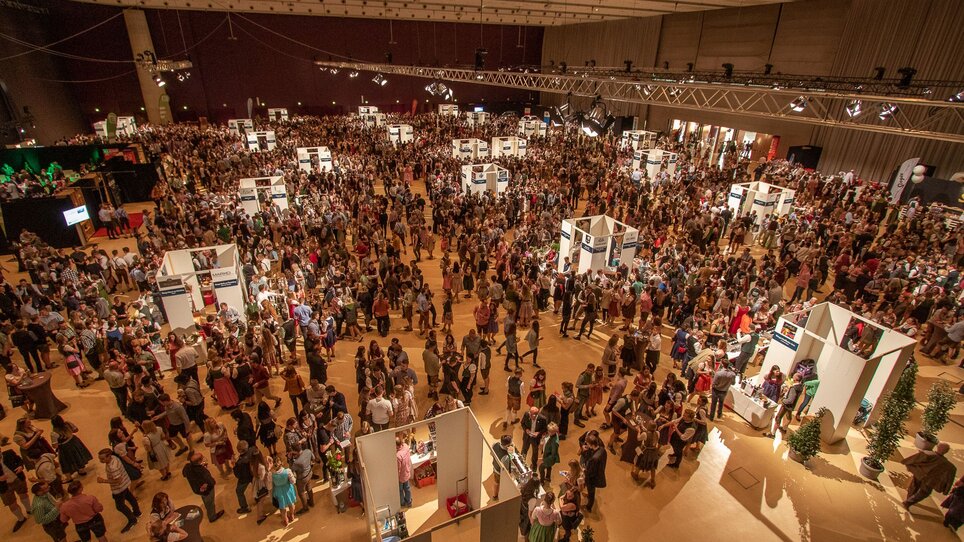 Crowded exhibition hall with booths and numerous visitors. | © Wein Steiermark - Fotokuchl