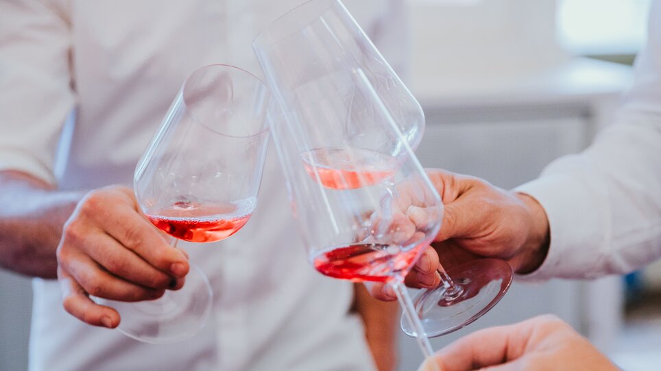 A close-up of three wine glasses filled with rosé wine as they clink glasses  | © Johanna Lamprecht