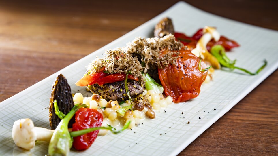 An artistic dish featuring truffles, vegetables, and pearl barley on a long plate. | © Graz Tourismus - Werner Krug