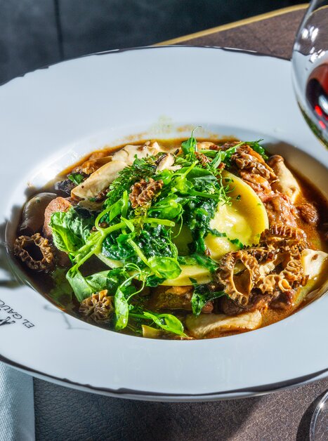Ein Teller mit Pasta, Trüffeln und frischen Kräutern, serviert mit einem Glas Rotwein. | © Paul Stajan