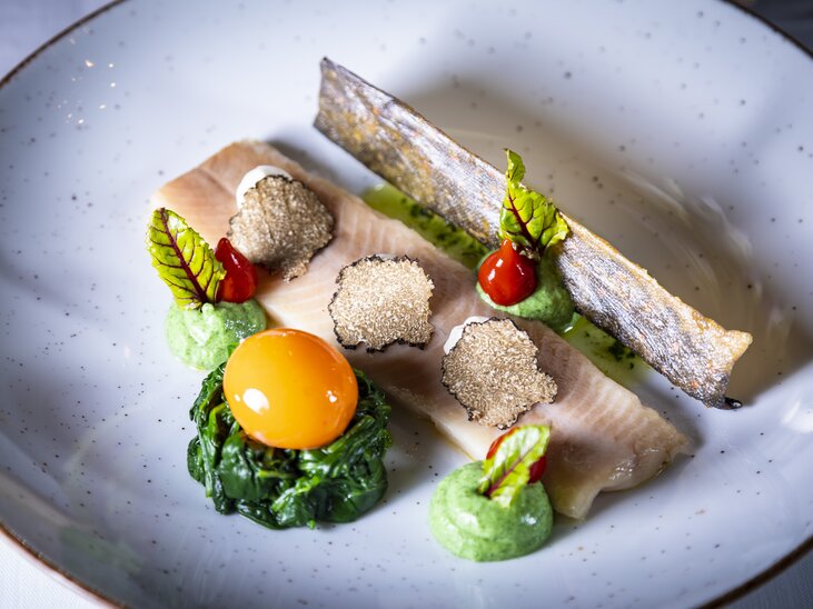 Ein delikates Trüffelgericht mit Fischfilet, Spinat, Eigelb und Trüffelscheiben. | © Graz Tourismus - Werner Krug
