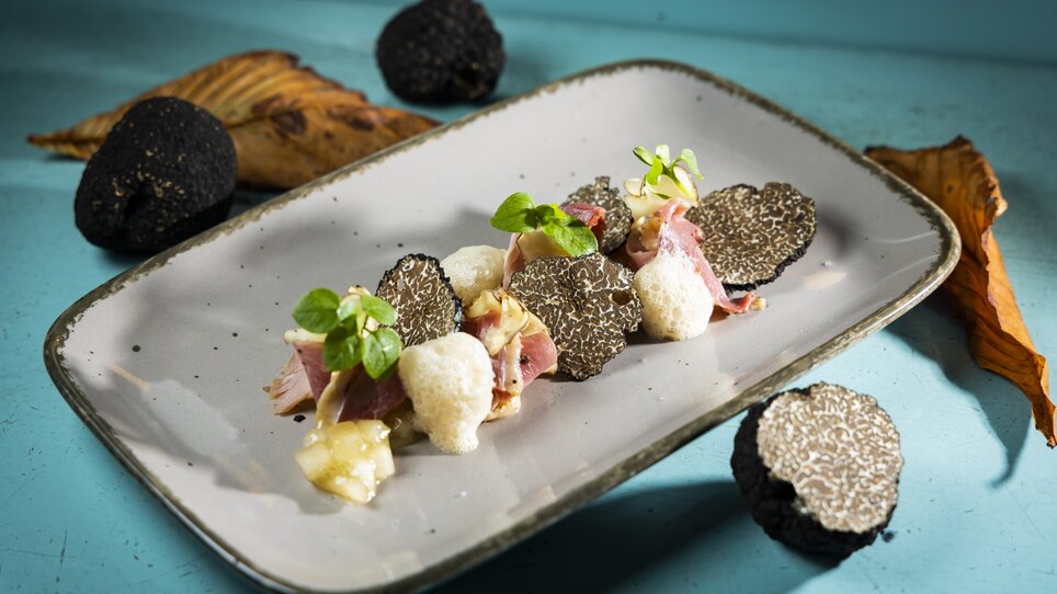 An elegant dish featuring truffles, ham, and herbs on a plate. | © Graz Tourismus - Werner Krug