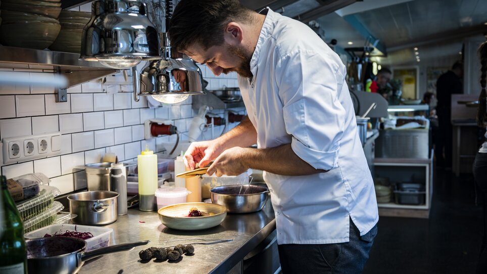 Chef preparing a truffle dish in a restaurant kitchen. | © Graz Tourismus - Werner Krug