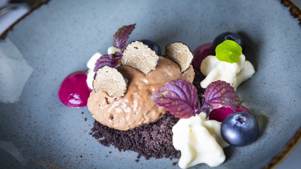 A dessert of chocolate mousse topped with truffle slices, berries, and cream. | © Graz Tourismus - Werner Krug