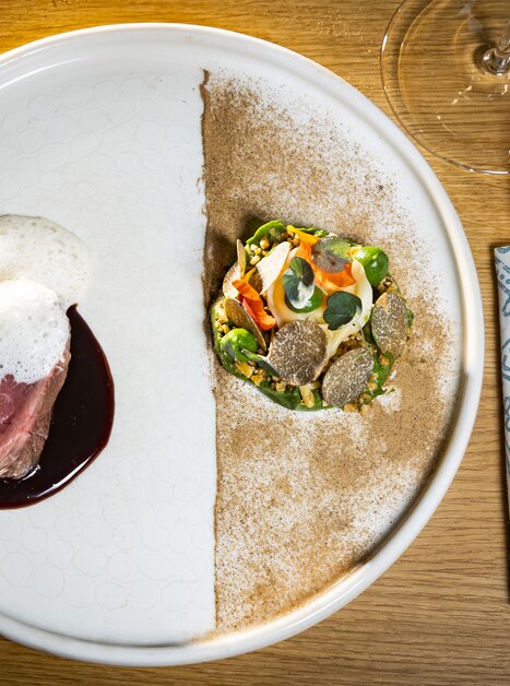Ein kunstvoll angerichteter Teller mit Fleisch, einer Soße und Gemüse. | © Graz Tourismus - Werner Krug