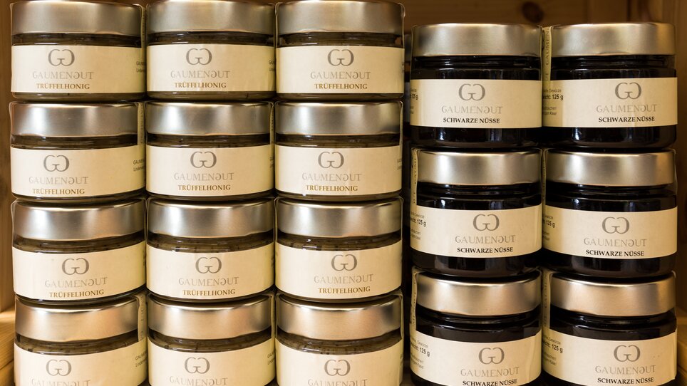 Una varietà di barattoli con miele al tartufo e noci nere sugli scaffali. | © Graz Tourismus Harry Schiffer