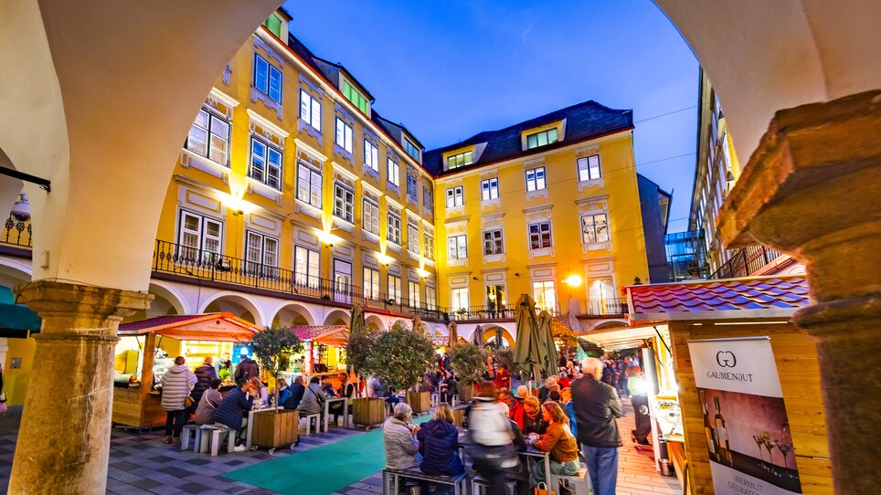 Belebter Trüffelmarkt im Paradeishof von Graz bei Nacht. | © Graz Tourismus - Werner Krug