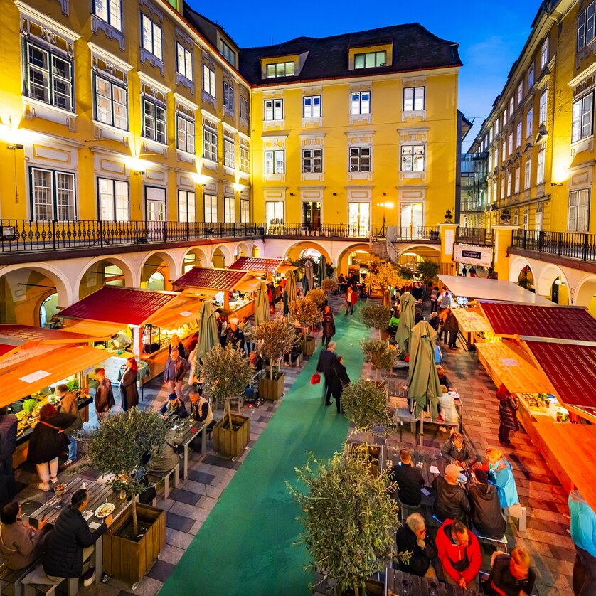 Market in the Paradeishof with truffle stands and guests at night. | © Graz Tourismus - Werner Krug
