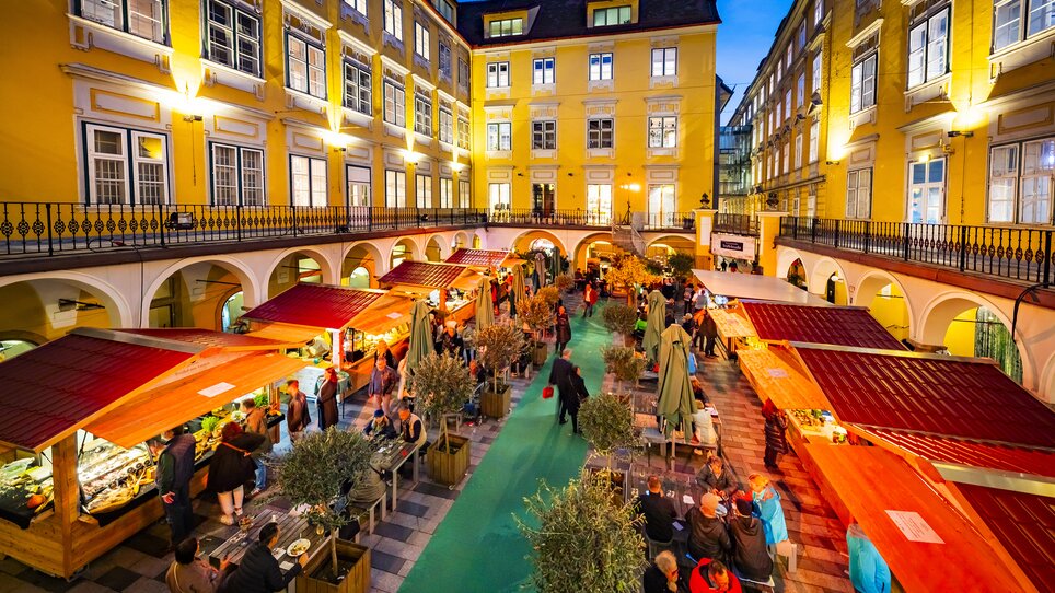 Markt im Paradeishof mit Trüffelständen und Gästen bei Nacht. | © Graz Tourismus - Werner Krug