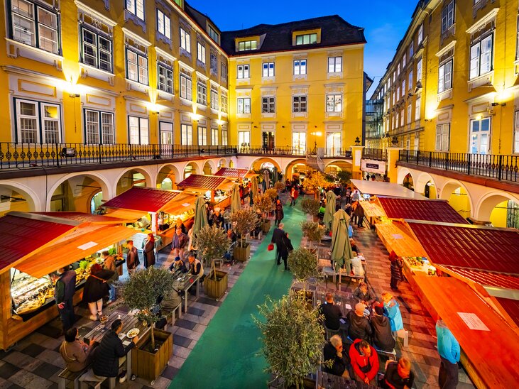 Markt im Paradeishof mit Trüffelständen und Gästen bei Nacht. | © Graz Tourismus - Werner Krug