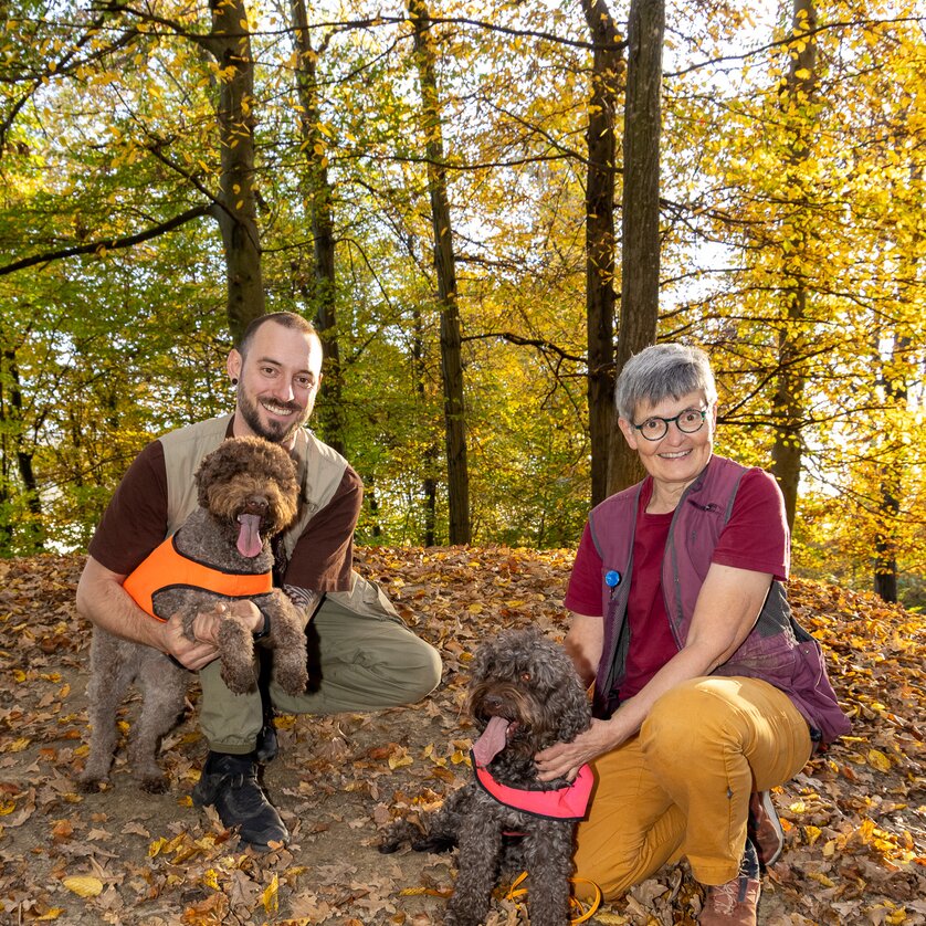 Two people with brown dogs in an autumn forest. | © Graz Tourismus - Harry Schiffer