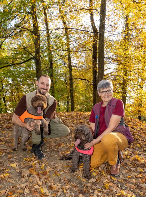 Zwei Personen mit braunen Hunden im Herbstwald. | © Graz Tourismus - Harry Schiffer