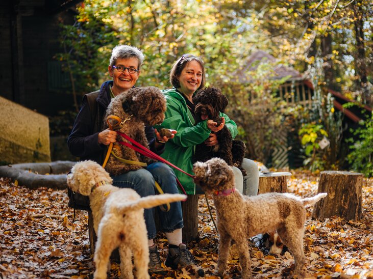 Zwei Frauen in einem bunten Herbstwald mit vier Hunden bei einer Trüffelwanderung im Grazer Leechwald. | © Gregor Hiebl
