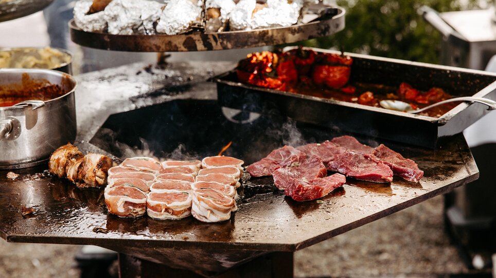Carne alla griglia e vari piatti su una griglia. | © Benjamin Gasser