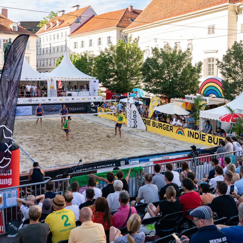 Footvolley ball match with spectators in Graz, surrounded by stands and tents. | © Mathias Kniepeiss