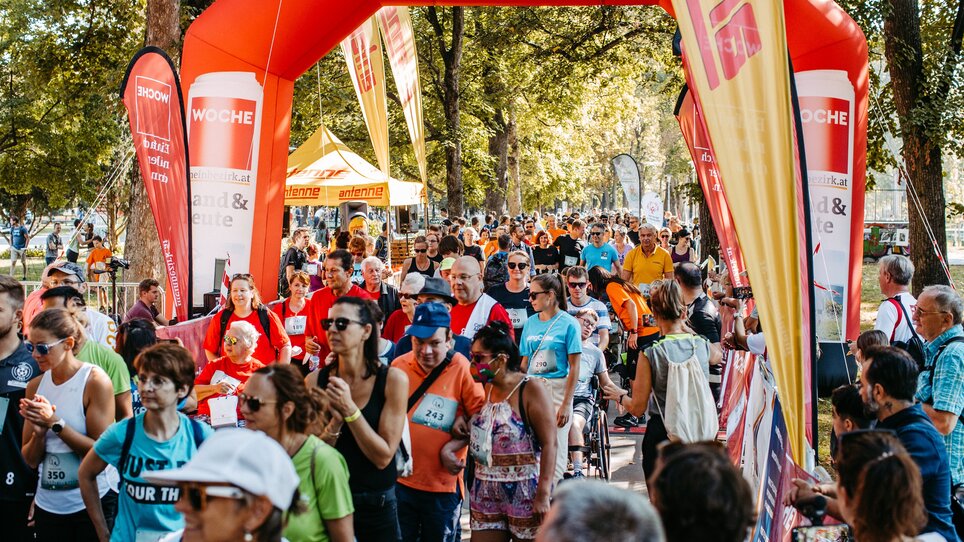 Teilnehmer beim Lauf-Event unter einem roten Tor, umgeben von Zuschauern. | © Mario Sudy