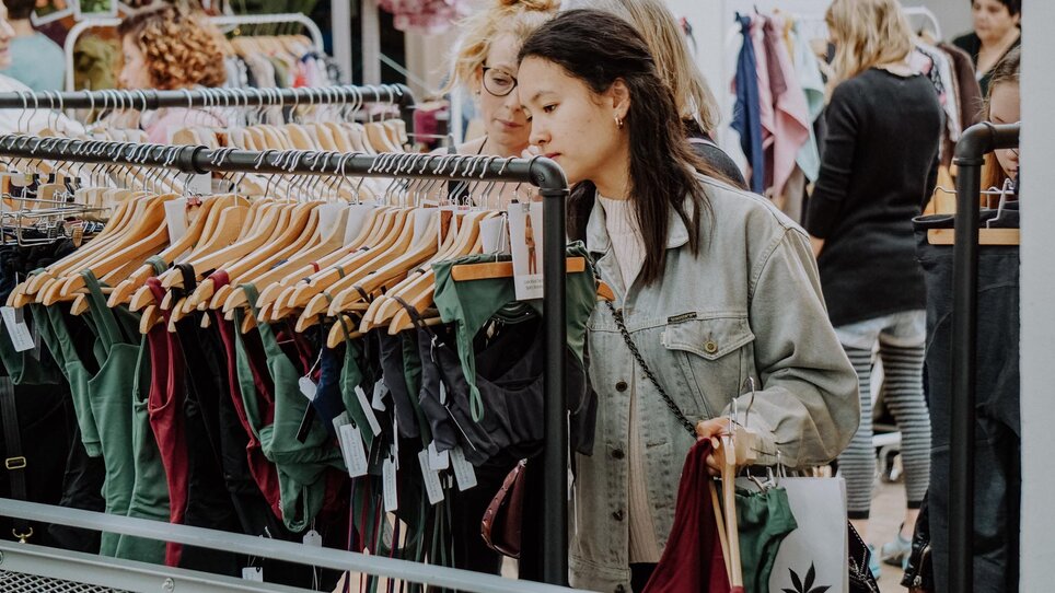 Due donne che sfogliano vestiti in un mercato a Graz. | © Kunst- und Designmarkt