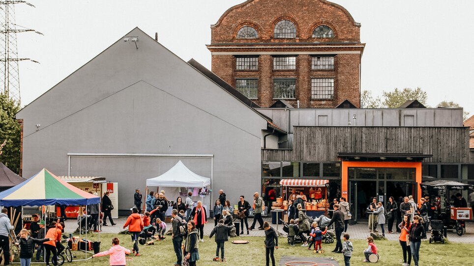 Un mercato affollato con stand, visitatori e attività all'aperto. | © Kunst und Designmarkt